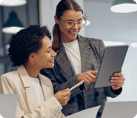 Duas mulheres conversando e olhando para um tablet