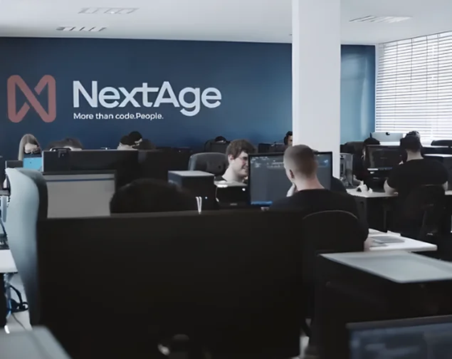 Equipe da NextAge trabalhando no escritório com o logotipo na parede