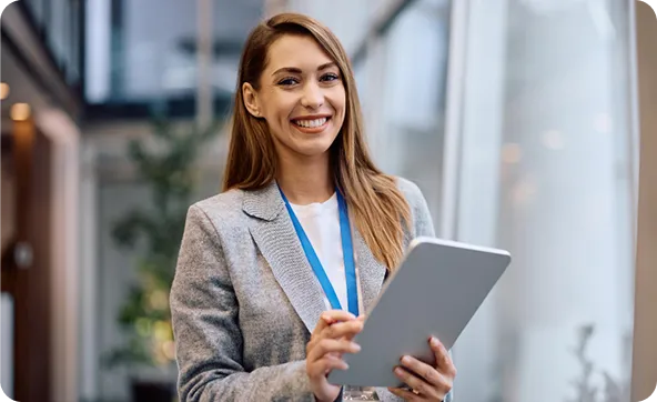 NextAge QA specialist smiling while holding a tablet in the office