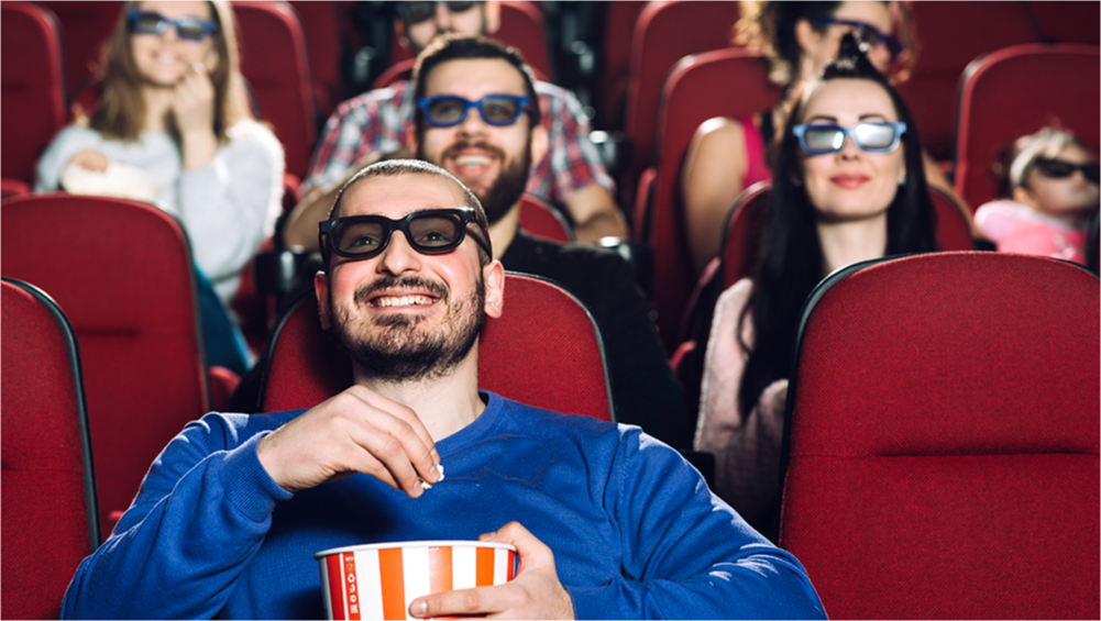 Pessoas no cinema assistindo filmes e comendo pipoca