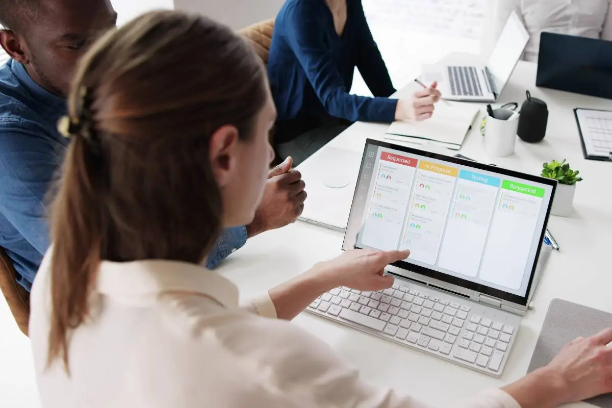 Development team using agile methodology with a digital Kanban board to manage tasks and stages of the software development life cycle.