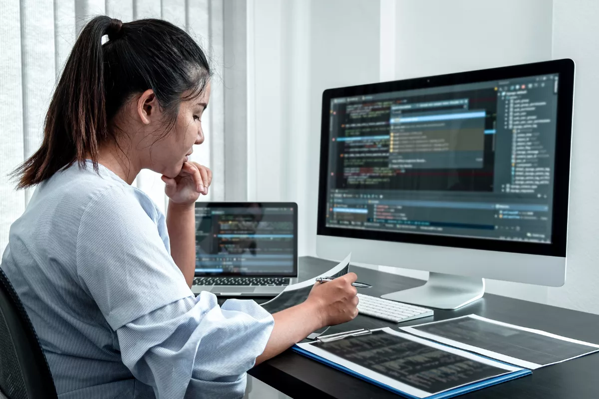 Mulher trabalhando no computador, focada na tela, representando produtividade, tecnologia e ambiente profissional.