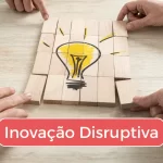 Peças de um quebra-cabeça formando uma lâmpada desenhada, com a inscrição "Inovação Disruptiva".