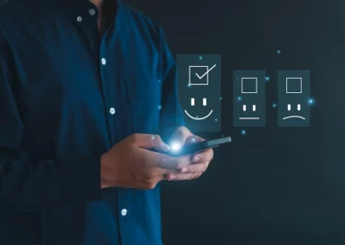 a man with a cellphone showing a happy face representing combing QA with AI.