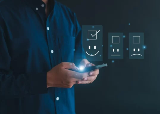 a man with a cellphone showing a happy face representing combing QA with AI.