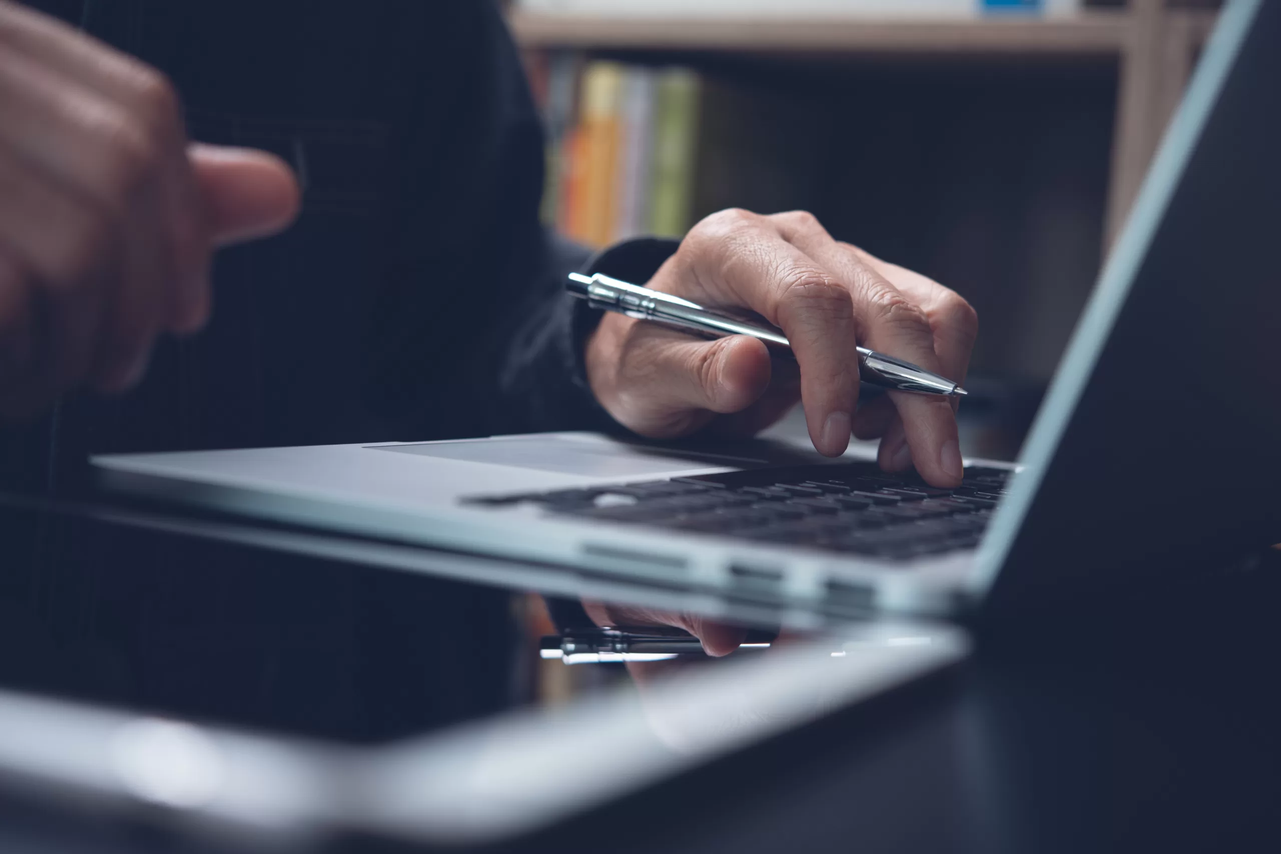 hands typing in a laptop holding a pencil representing lifelong learning