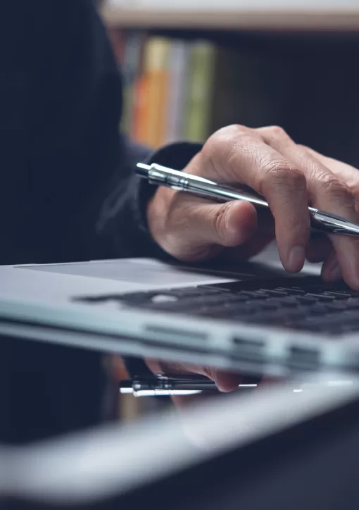 Imagem de mão digitando no computador segurando um lápis representando lifelong learning