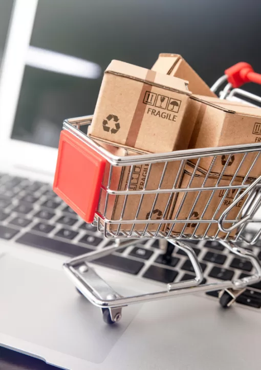 Imagem de um carrinho de compras em cima de um notebook representando outsourcing para e-commerce