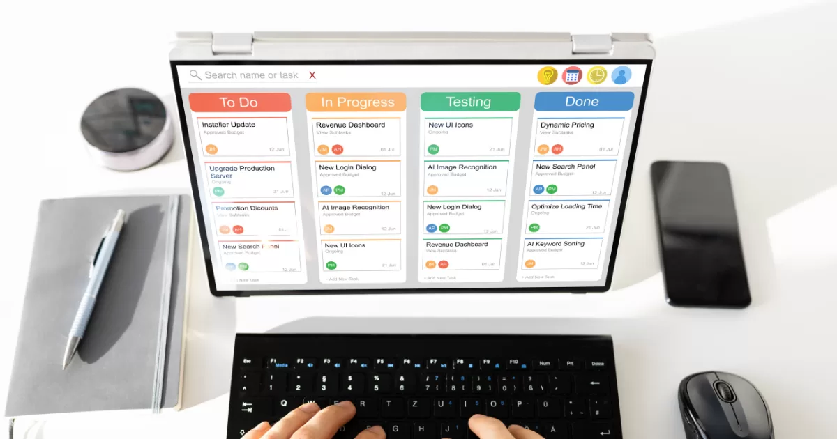 duas mãos digitando em um laptop mostrando um kanban