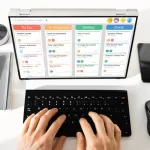 duas mãos digitando em um laptop mostrando um kanban