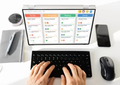 duas mãos digitando em um laptop mostrando um kanban