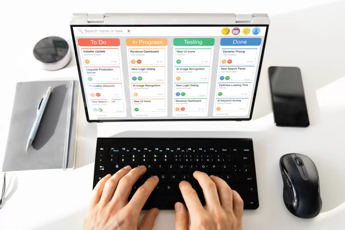 duas mãos digitando em um laptop mostrando um kanban