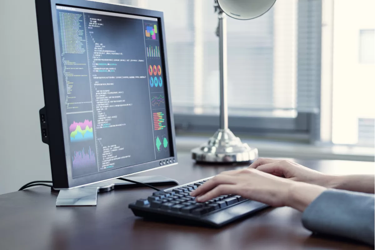 Profissional programando em um notebook com editor de código aberto, trabalhando em um escritório com decoração industrial.
