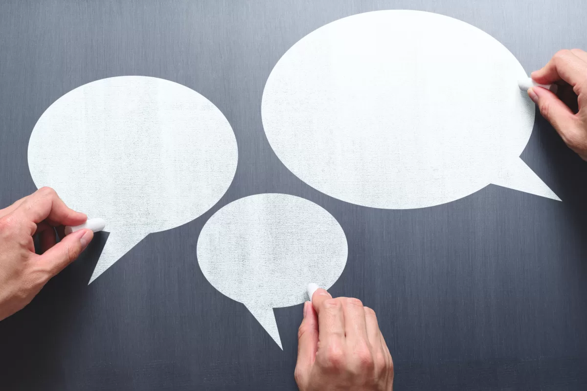 Three speech bubbles representing communication between IT teams, symbolizing collaboration and information sharing.