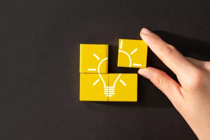 Quatro blocos amarelos formando uma lâmpada, representando inovação, ideias criativas e soluções estratégicas para empresas, representando o processo de validar projetos