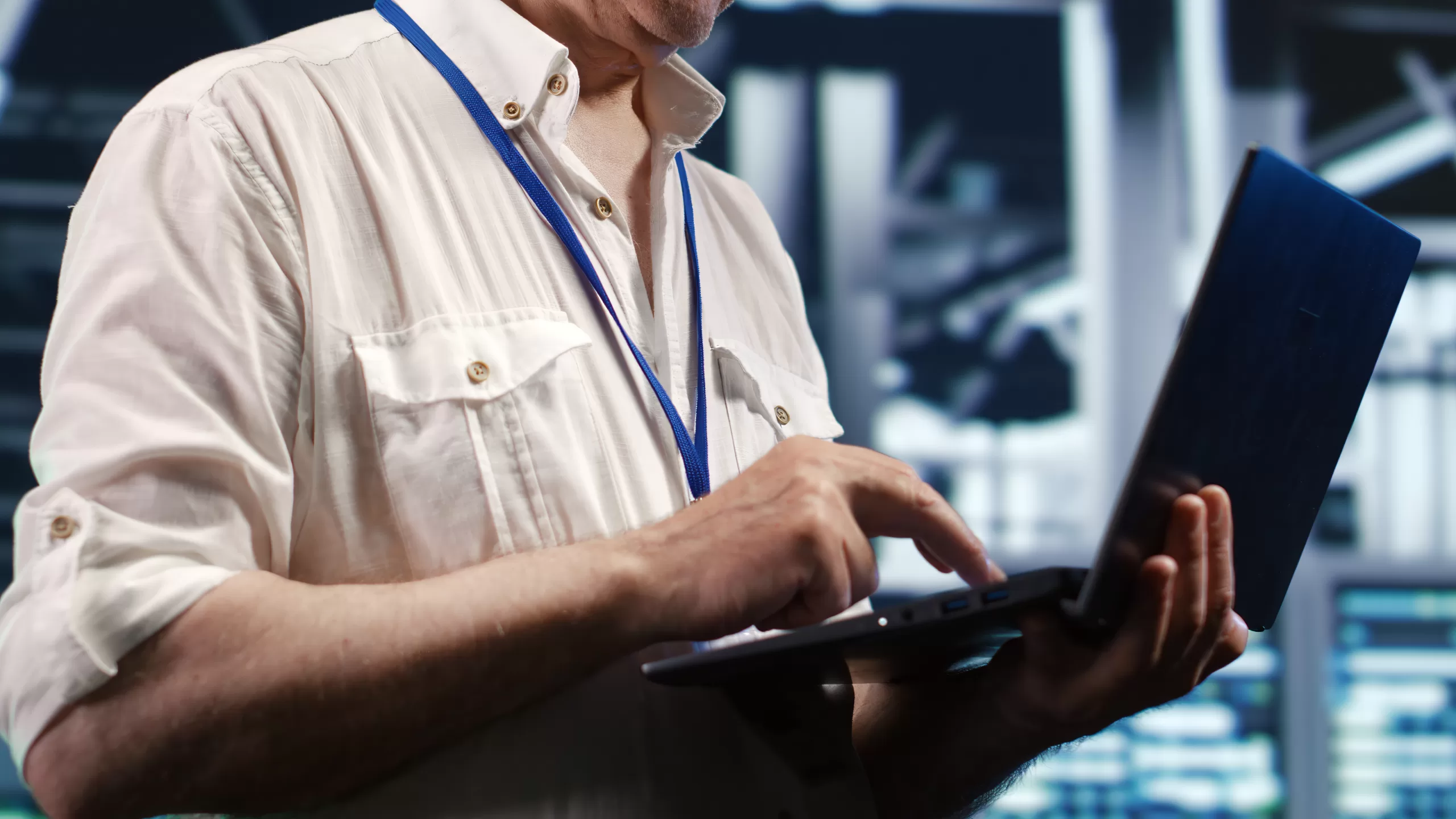 Profissional operando notebook em um ambiente de servidores ou centro de dados. 