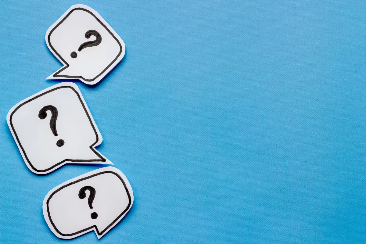 White speech bubbles with question marks on a blue background.