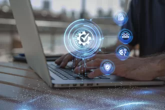 Digital quality control and modernization concept: a gear with a check mark floating over a laptop, symbolizing diagnosis and system optimization.