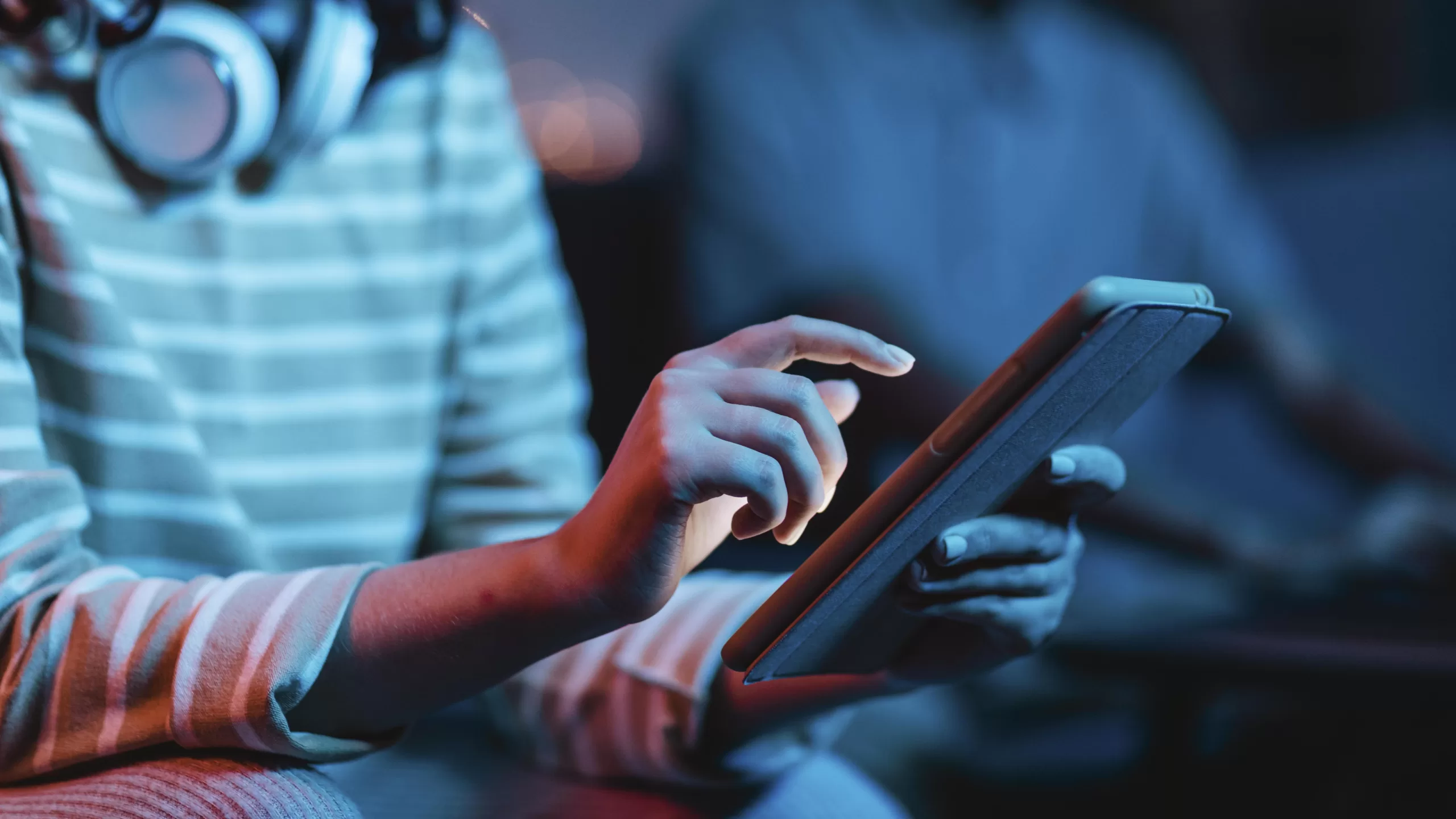 Developer working on laptop with programming code on screen in integrated development environment (IDE) with blue lighting in the background representing technology trends 2026