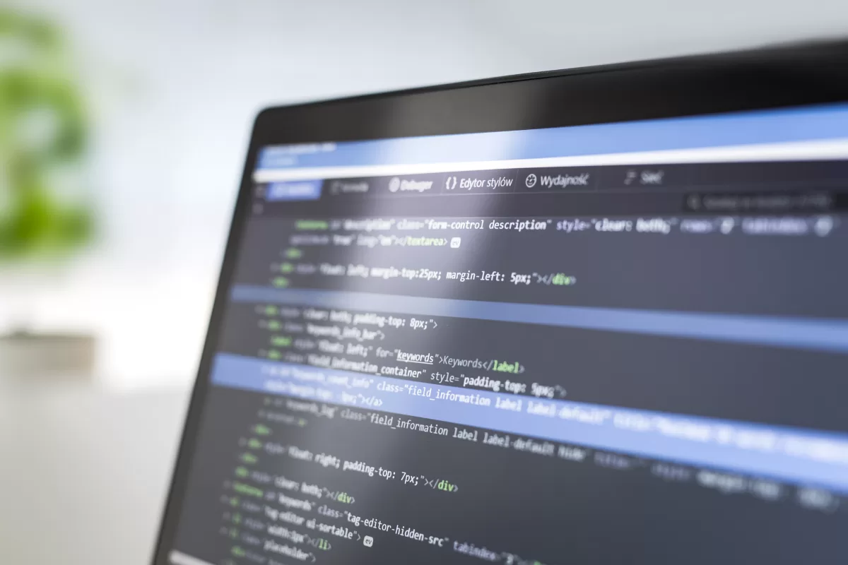 Laptop screen displaying HTML and CSS code in dark-themed code editor