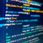 Close-up de código de programação JavaScript em monitor, com sintaxe colorida e comandos de script