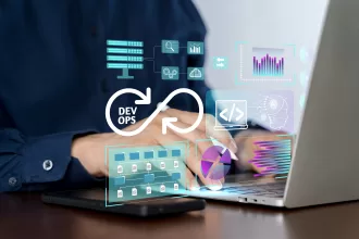 Imagem em close das mãos de uma pessoa digitando em um laptop, sobreposta por ícones digitais futuristas representando práticas DevOps. Há um símbolo do infinito com a palavra "DEVOPS" no centro, cercado por gráficos de servidores, pastas, código e análise de dados.