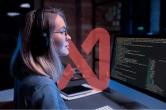 Pessoa segurando tablet com interface de dados integrados em ambiente de monitoramento com telas ao fundo.