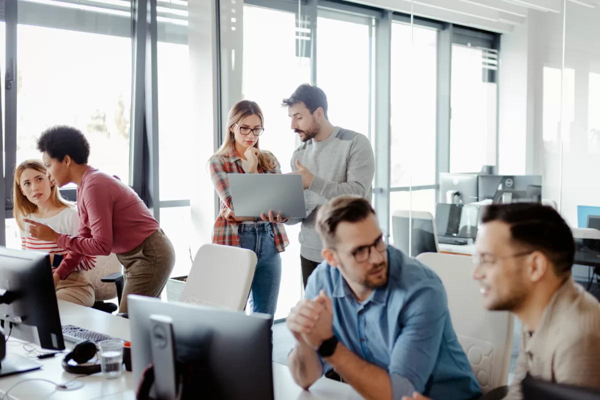 Equipe de tecnologia colaborando em projeto de desenvolvimento de software em escritório