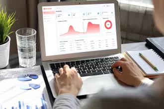 Pessoa mexendo no laptop com a tela dos gráficos do NextFlow AI, serviço da NextAge.