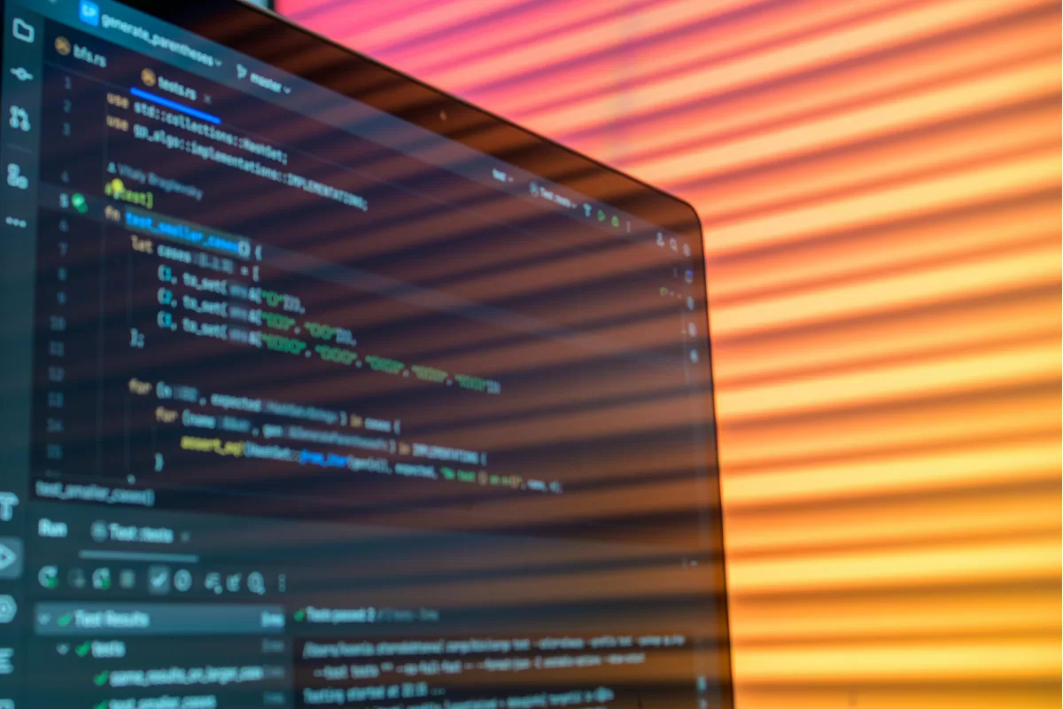 Code editor screen with colorful syntax highlighting in a dark environment, illustrating software development and testing
