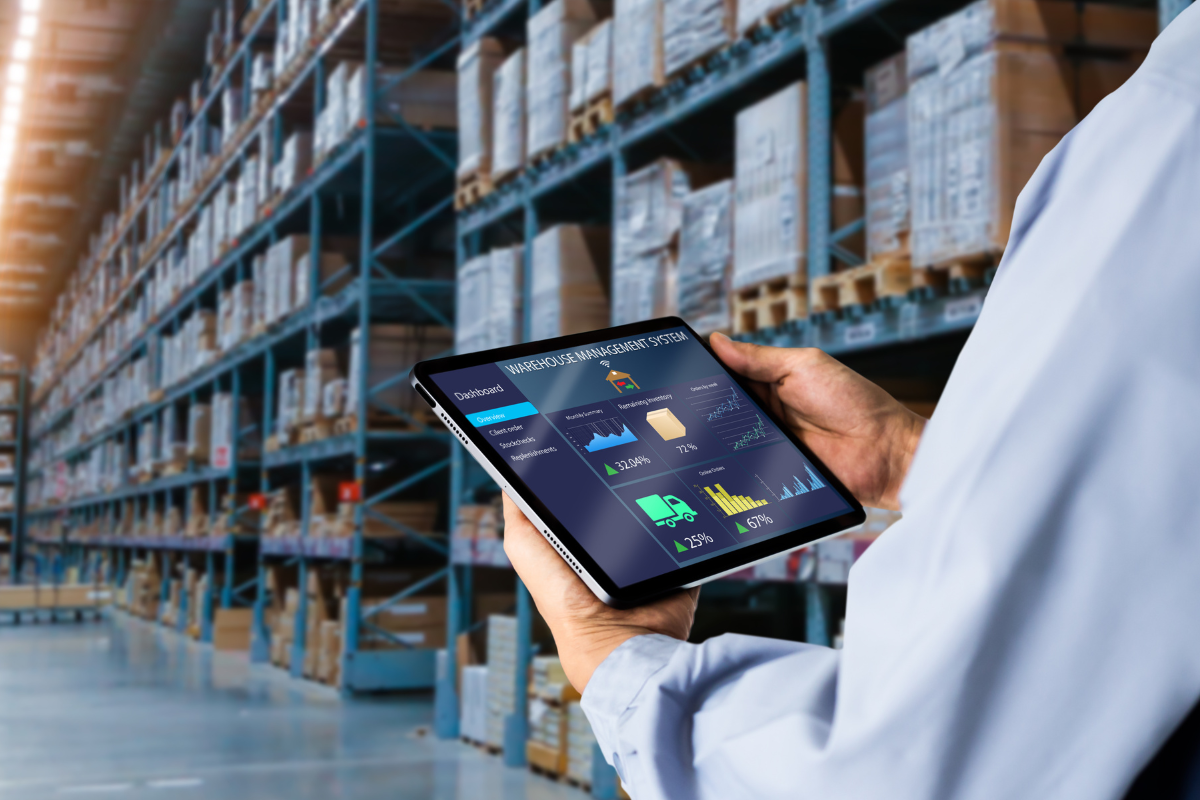 Gestor consultando sistema de gestão de estoque em tablet dentro de armazém