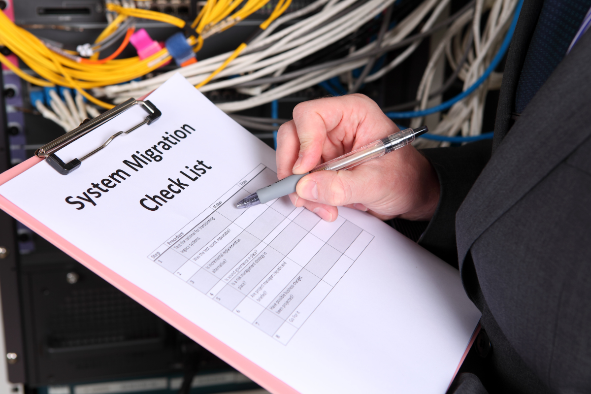 IT professional reviewing a system migration checklist in front of a server rack
