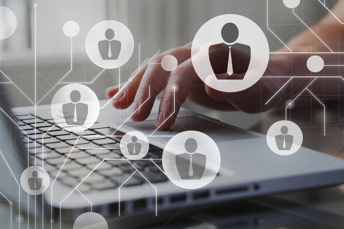 Hands typing on a laptop with a network of connected professional icons, representing AI-powered HR people management