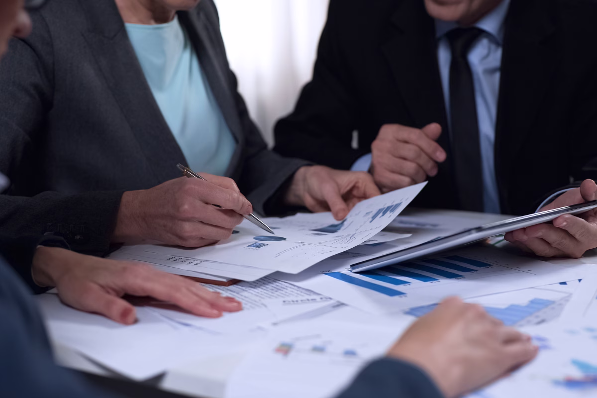 Corporate team analyzing reports and charts in an artificial intelligence governance meeting