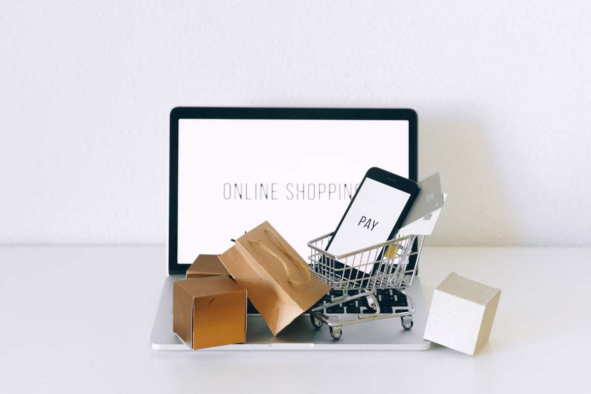 Carrinho de compras com embalagens e smartphone representando o processo de compra em marketplace online