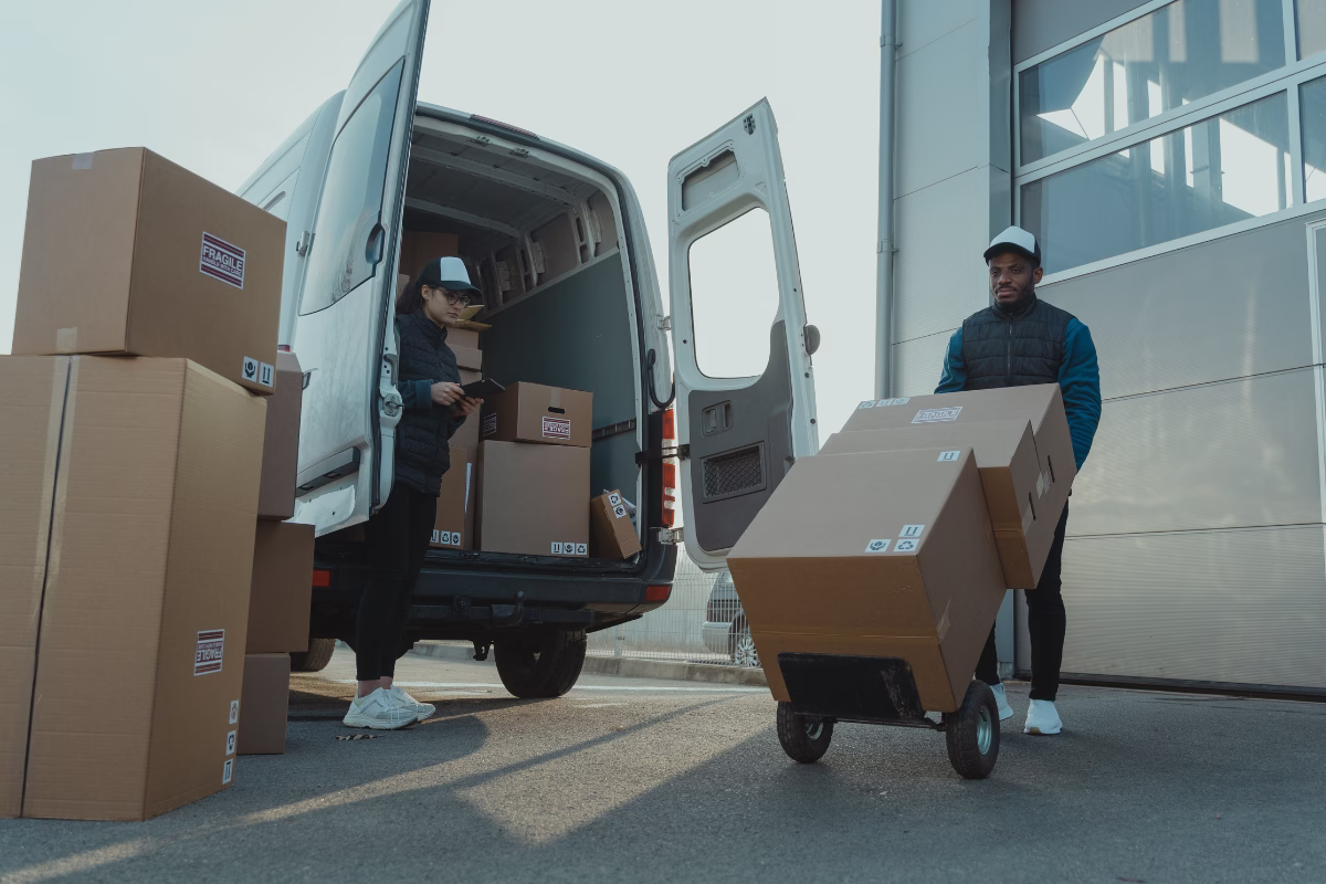 Delivery team loading boxes into a van during freight consolidation for transport