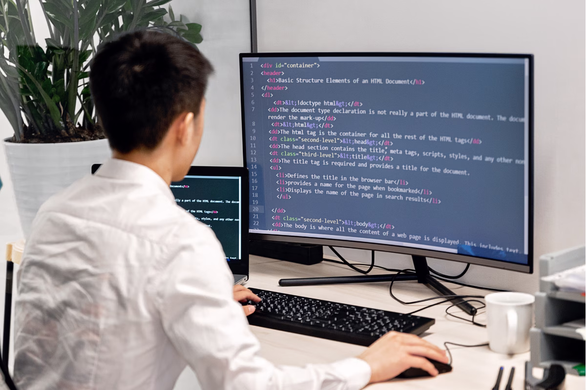 Desenvolvedor trabalhando com código HTML em monitor — empresas que cresceram com alocação de desenvolvedores