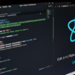 Monitor exibindo o logo do React.js e um editor de código com desenvolvimento frontend em ambiente local