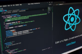 Monitor exibindo o logo do React.js e um editor de código com desenvolvimento frontend em ambiente local