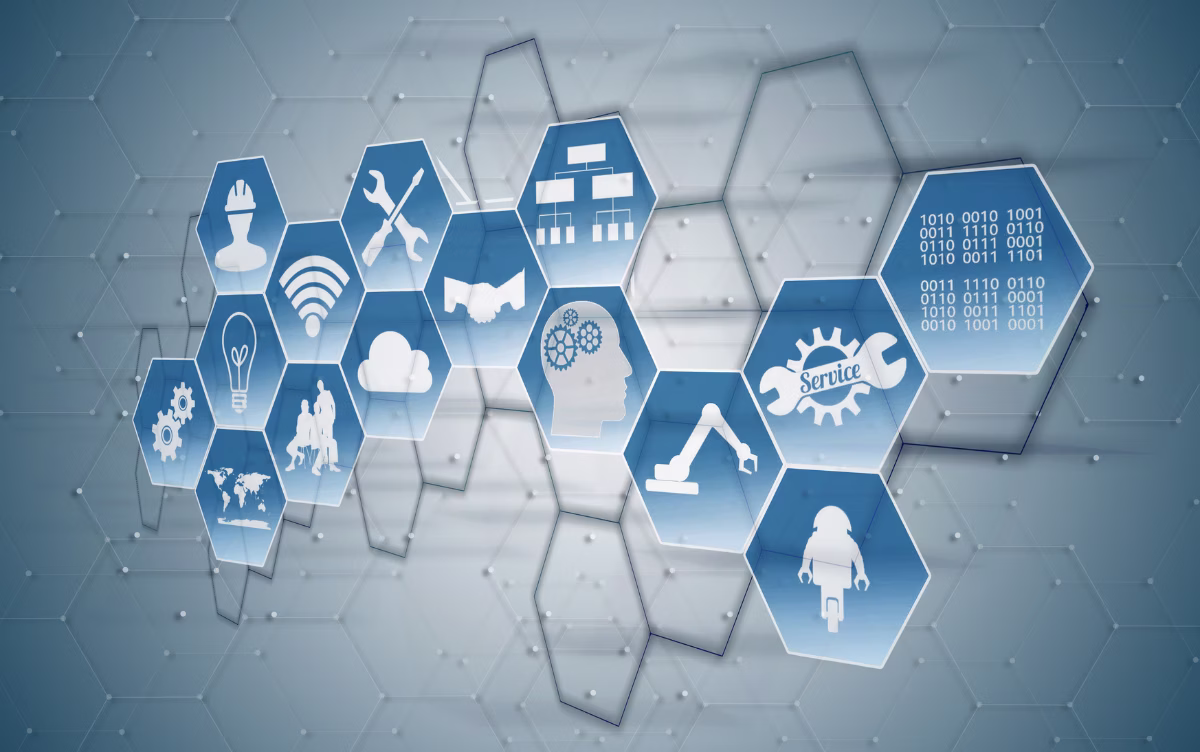 Abstract digital art with a gray background and a network of connected hexagons. In the center, blue hexagons highlight various white tech and industry icons: gears, a human head silhouette with internal gears, an industrial robotic arm, crossed tools, a cloud, and lines of binary code.