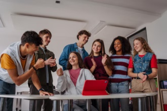 Um grupo de adolescentes utilizando tablet representando desenvolvimento de software para educação