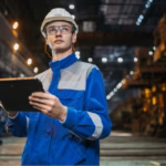 Um trabalhador em uma indústria segurando um tablet representando MES vs ERP