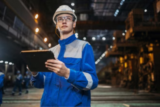 Um trabalhador em uma indústria segurando um tablet representando MES vs ERP