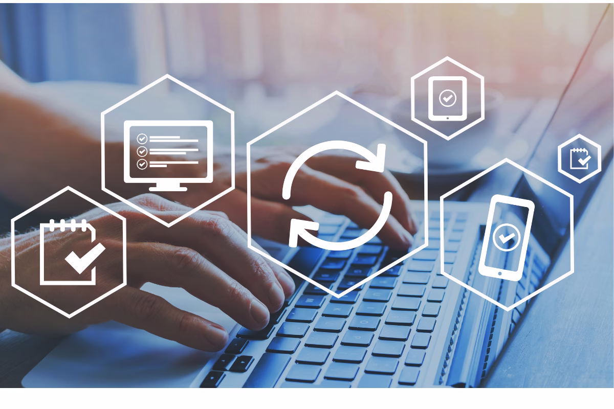 Mãos de um profissional digitando no teclado de um notebook com ícones digitais sobrepostos de automação, testes de software, dispositivos móveis e listas de checagem.