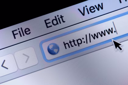 Close-up da tela de um monitor mostrando a barra de endereço de um navegador web antigo ou clássico. O cursor do mouse em formato de seta preta aponta para o campo de texto que exibe o início de uma URL com "http://www. ", evidenciando os pixels da tela e o menu superior com as opções File, Edit e View.