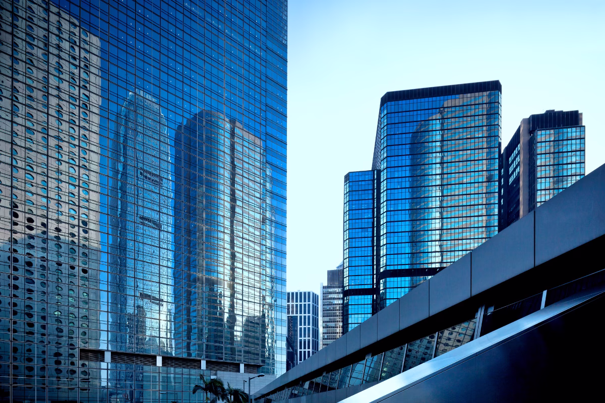Glass-facade skyscrapers reflecting other buildings in a commercial district