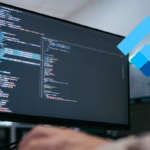 Tela de computador exibindo código de um dashboard com o logo do Flutter em destaque, representando desenvolvimento Flutter para Web