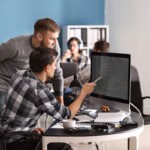 Equipe de desenvolvedores de software colaborando em projeto de tecnologia no escritório
