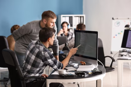 Equipe de desenvolvedores de software colaborando em projeto de tecnologia no escritório