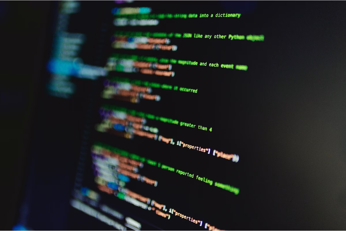 Close-up de tela de computador exibindo código Python, com script que processa dados em formato JSON